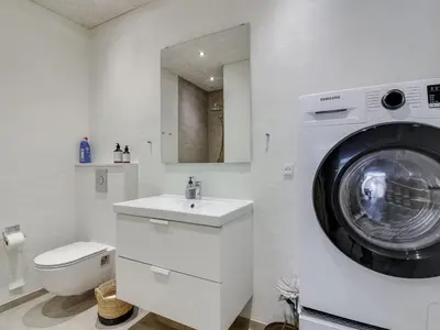 a bathroom with a washing machine and a sink at Holiday Home Laulu - 2km from the sea by Interhome in Blokhus