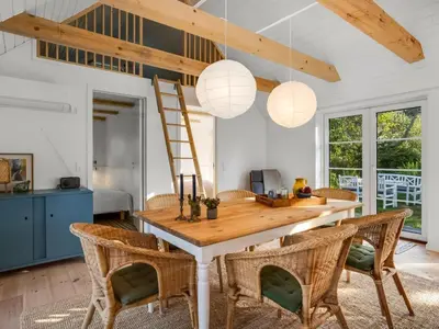 a dining room with a wooden table and chairs at Holiday Home Beghel - 350m from the sea by Interhome in Blokhus