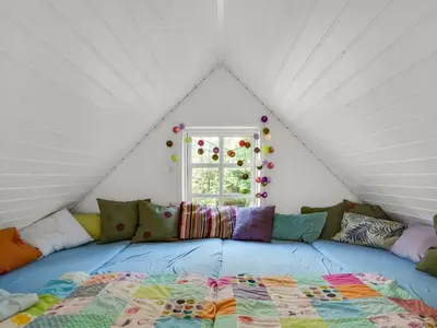 a bed in a room with a comforter at Holiday Home Beghel - 350m from the sea by Interhome in Blokhus