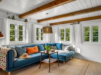 a living room with a blue couch and a table at Holiday Home Beghel - 350m from the sea by Interhome in Blokhus