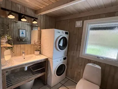 a bathroom with a washing machine and a sink at Holiday Home Nilson - 1-4km from the sea by Interhome in Blokhus