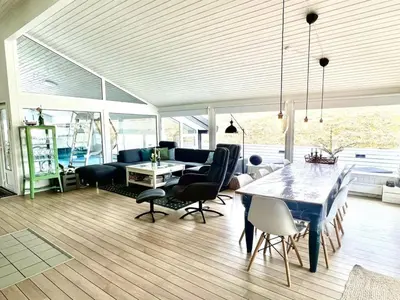 a living room with a dining table and chairs at Holiday Home Nilson - 1-4km from the sea by Interhome in Blokhus