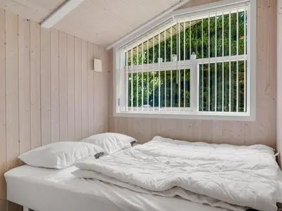 a white bed in a room with a window at Holiday Home Barnet - 2-2km from the sea by Interhome in Blokhus