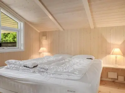 a white bed in a room with a window at Holiday Home Barnet - 2-2km from the sea by Interhome in Blokhus