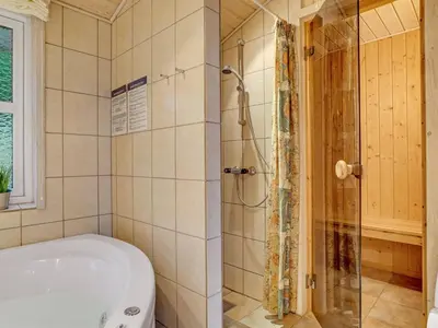a bathroom with a tub and a shower at Holiday Home Sighwarth - 350m from the sea by Interhome in Saltum
