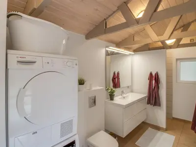 a bathroom with a washing machine and a sink at Holiday Home Diuri - 400m from the sea by Interhome in Saltum