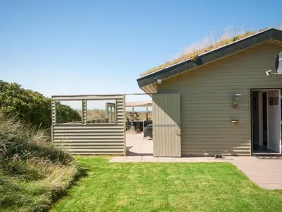 a house with a grass yard in front of it at Holiday Home Diuri - 400m from the sea by Interhome in Saltum