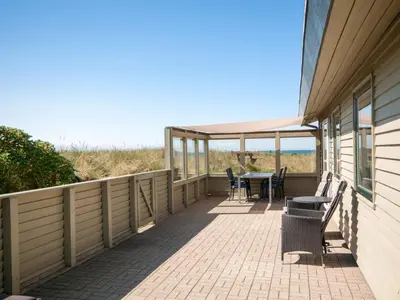 a patio with a table and chairs on a house at Holiday Home Diuri - 400m from the sea by Interhome in Saltum