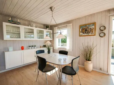a dining room with a white table and chairs at Holiday Home Diuri - 400m from the sea by Interhome in Saltum