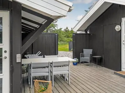 a patio with a white table and chairs on a deck at Holiday Home Eivy - 1km from the sea by Interhome in Saltum