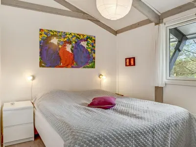 a bedroom with a bed and a painting on the wall at Holiday Home Eivy - 1km from the sea by Interhome in Saltum