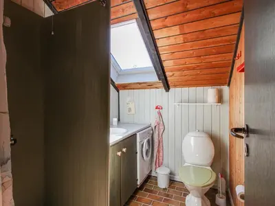 a bathroom with a toilet and a sink and a window at Holiday Home Maritha - 950m from the sea by Interhome in Saltum
