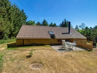a small house with a picnic table in front of it at Holiday Home Maritha - 950m from the sea by Interhome in Saltum