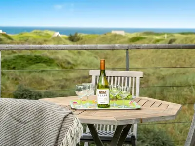 a bottle of wine sitting on a table with glasses at Holiday Home Josten - 500m from the sea by Interhome in Saltum