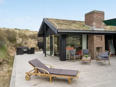 a patio with chairs and a bench on a house at Holiday Home Simeona - 140m from the sea by Interhome in Saltum