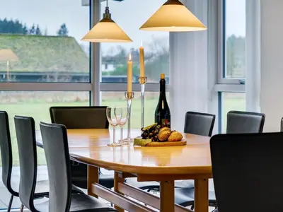 a dining room table with a bottle of wine and wine glasses at Holiday Home Ricus - 1-8km from the sea by Interhome in Saltum