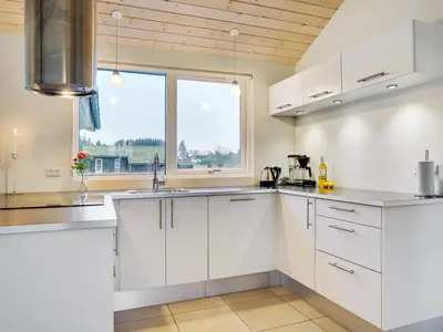 a kitchen with white cabinets and a window at Holiday Home Ricus - 1-8km from the sea by Interhome in Saltum