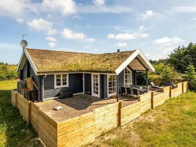 a small blue house with a wooden fence at Holiday Home Annemie - 1-8km from the sea by Interhome in Saltum