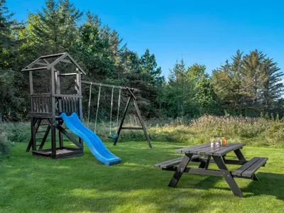 a playground with a slide and a picnic table at Holiday Home Javorka - 1-4km from the sea by Interhome in Saltum