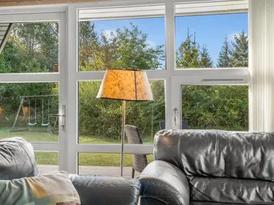 a living room with a couch and a lamp and windows at Holiday Home Mechthild - 2-7km from the sea by Interhome in Saltum