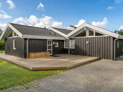 a house with a wooden deck in front of it at Holiday Home Mechthild - 2-7km from the sea by Interhome in Saltum