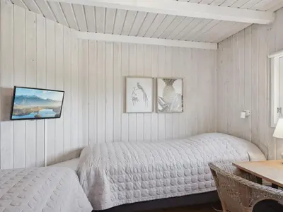 a bedroom with two beds and a table and a desk at Holiday Home Dijana - 150m from the sea by Interhome in Saltum