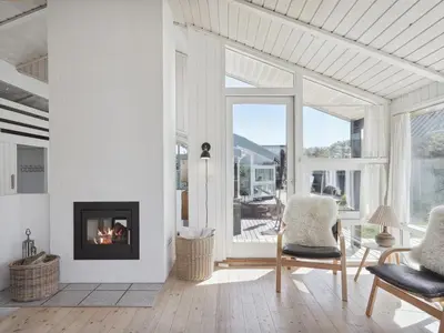 a living room with a fireplace and two chairs at Holiday Home Dijana - 150m from the sea by Interhome in Saltum