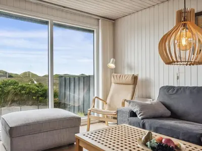 a living room with a couch and a chair and a window at Holiday Home Aghe - 250m from the sea by Interhome in Saltum
