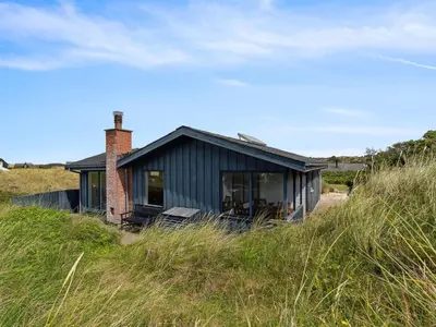 a small blue house sitting on top of a hill at Holiday Home Aghe - 250m from the sea by Interhome in Saltum