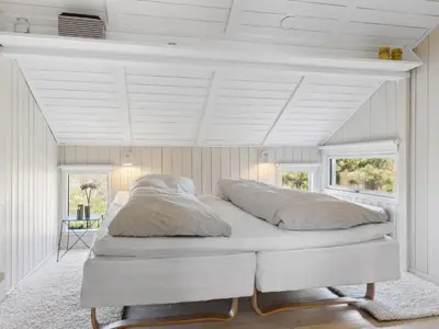 a white bed in a room with two pillows at Holiday Home Allida - 800m from the sea by Interhome in Saltum