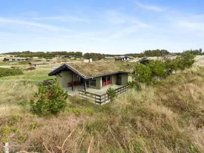 a small house with a grass roof in a field at Holiday Home Maini - 600m from the sea by Interhome in Saltum