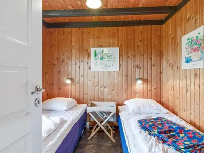 two beds in a room with wooden walls at Holiday Home Maini - 600m from the sea by Interhome in Saltum