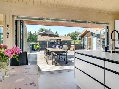 a kitchen with a deck with a table and chairs at Holiday Home Dorothe - 1-4km from the sea by Interhome in Saltum