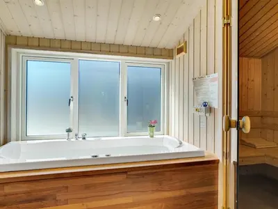 a large bath tub in a room with a window at Holiday Home Dorothe - 1-4km from the sea by Interhome in Saltum