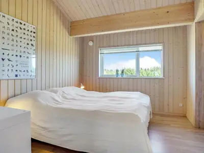 a bedroom with a white bed and a window at Holiday Home Dorothe - 1-4km from the sea by Interhome in Saltum