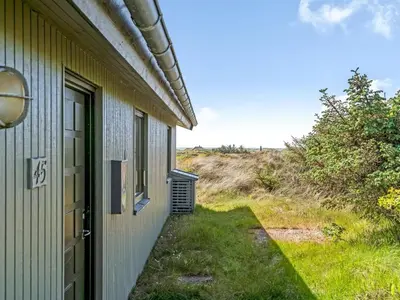 a door to a house with a grassy yard at Holiday Home Ehawee - 350m from the sea by Interhome in Saltum