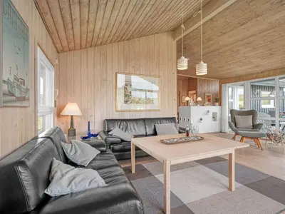 a living room with a couch and a table at Holiday Home Rosemari - 260m from the sea by Interhome in Saltum
