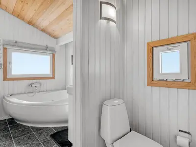 a bathroom with a white toilet and a sink at Holiday Home Rosemari - 260m from the sea by Interhome in Saltum