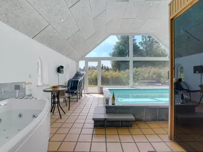 a large bathroom with a tub and a swimming pool at Holiday Home Iben - 2-3km from the sea by Interhome in Saltum