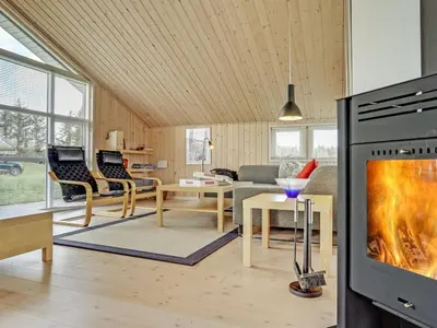 a living room with a fireplace and a tv at Holiday Home Frerich - 1-5km from the sea by Interhome in Saltum
