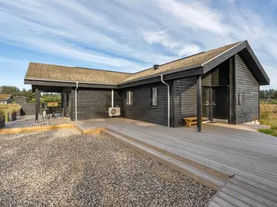 a house with a wooden deck in front of it at Holiday Home Carla - 1-5km from the sea by Interhome in Saltum