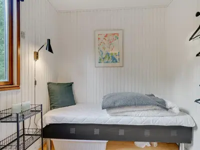 a bed in a room with a white wall at Holiday Home Antoinetta - 900m from the sea by Interhome in Saltum