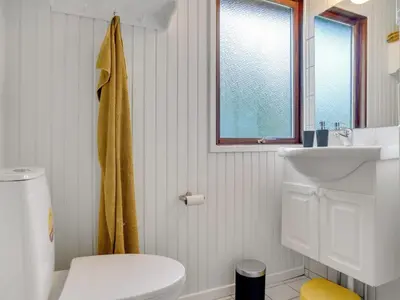a bathroom with a white toilet and a sink at Holiday Home Antoinetta - 900m from the sea by Interhome in Saltum