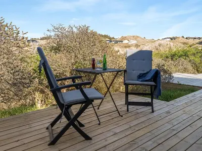 two chairs and a table on a deck at Holiday Home Felis - 200m from the sea by Interhome in Saltum