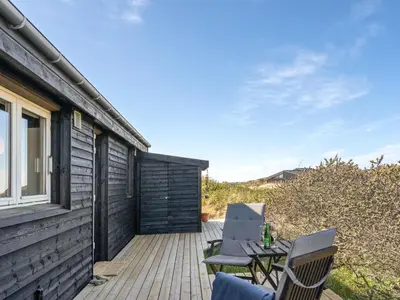 a patio with chairs and a table on a deck at Holiday Home Felis - 200m from the sea by Interhome in Saltum