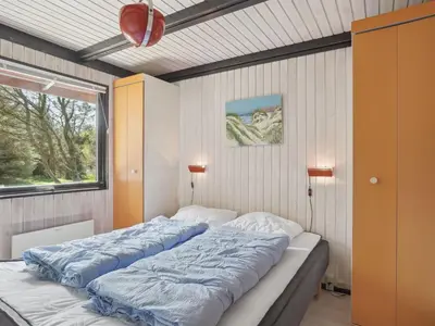 a large bed in a room with a window at Holiday Home Therbern - 1-7km from the sea by Interhome in Saltum