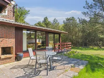 a patio with a table and two chairs and a fireplace at Holiday Home Therbern - 1-7km from the sea by Interhome in Saltum