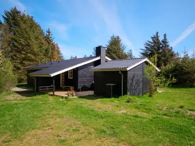a cabin in a field next to a grass field at Holiday Home Maunu - 1-2km from the sea by Interhome in Saltum
