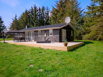 a house with a deck in a yard at Holiday Home Maunu - 1-2km from the sea by Interhome in Saltum