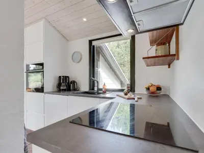 a kitchen with white counters and a large window at Holiday Home Kadife - 750m from the sea by Interhome in Saltum